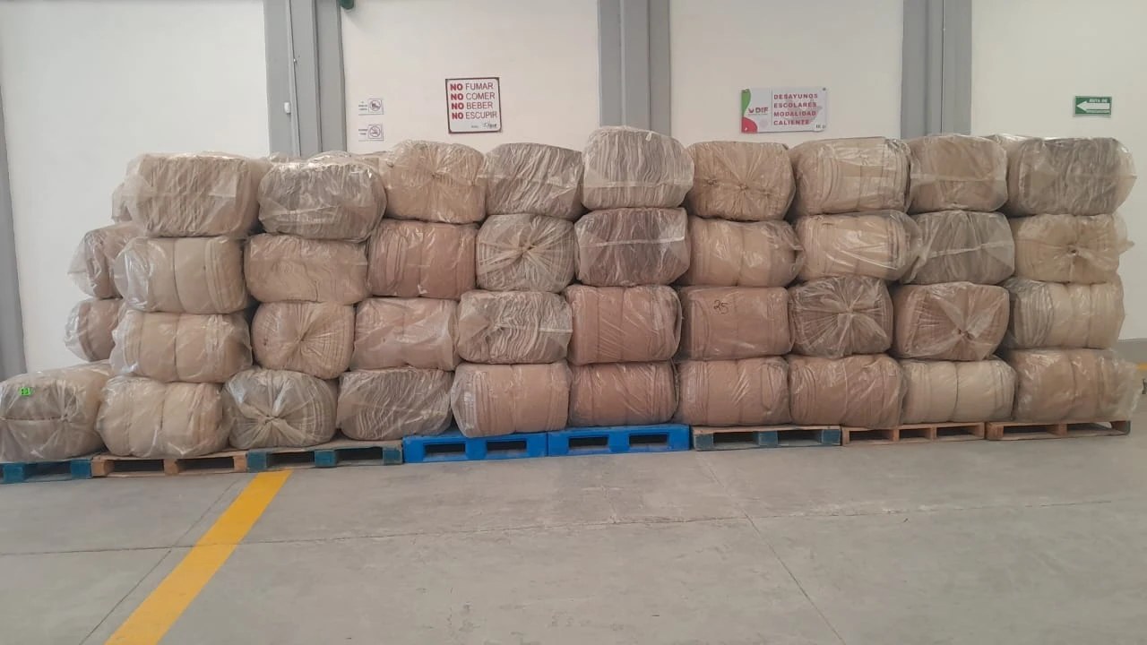 Paquetes de cobijas protegidos y apilados en un área de almacenamiento