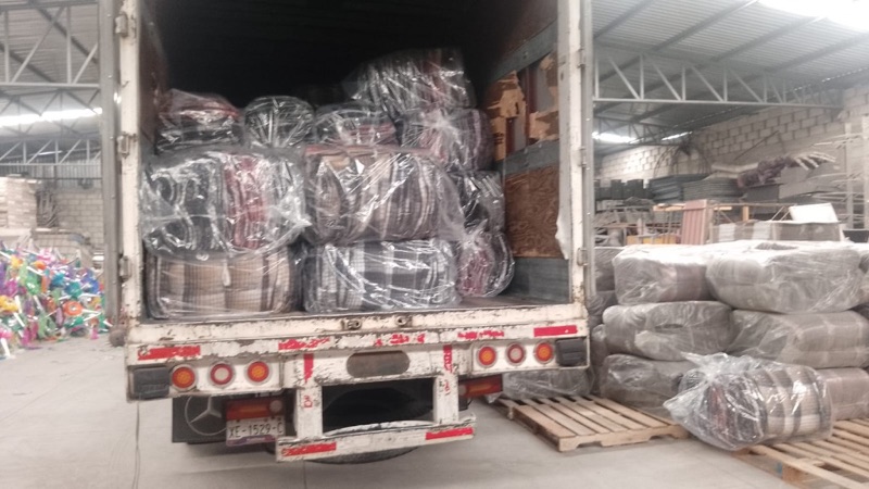 Paquetes de cobijas acomodados en un vehículo de transporte