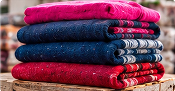 Modelos de cobijas tejidas dobladas en distintos colores disponibles para programas sociales