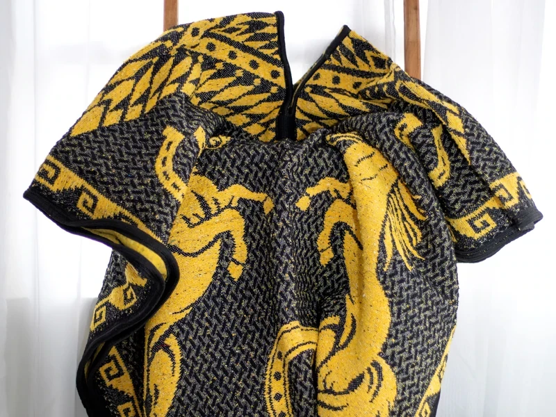Gabán negro con diseño en amarillo, fotografía del producto