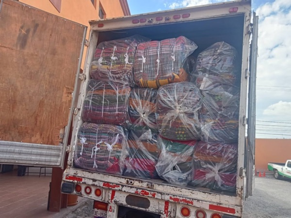 Camión de carga completa con paquetes de cobijas para distribución nacional.
